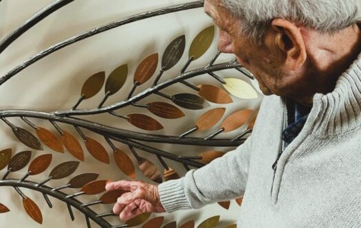 A visitor viewing the engraved leaves on the Tree of Life at the ont-size:15px; line-height:1.5; font-style:italic;